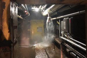 Water spraying from fire sprinkler in flooded underground facility.