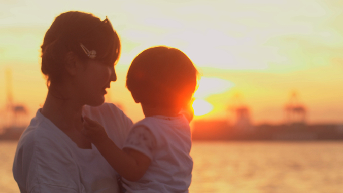 Silhouette of mother and child at sunset.